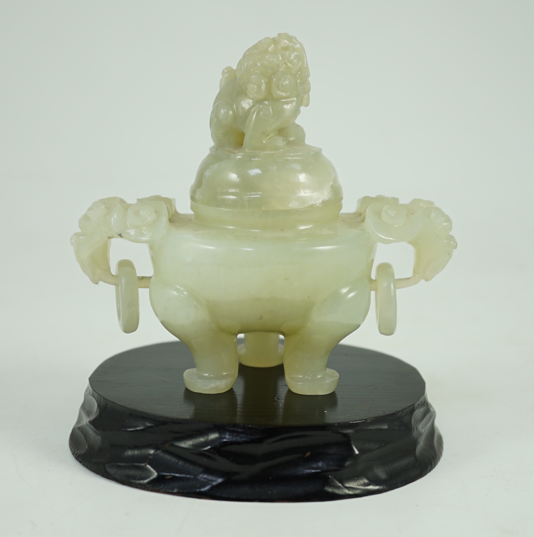 A Chinese pale celadon jade tripod censer cover, 20th century, 12cm wide, wood stand